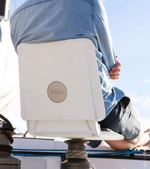 Person relaxing on a portable winch seat for sailboat, enjoying comfort on the water.